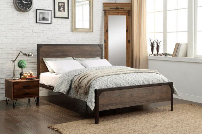 Wood and metal bed and pedestal in rustic bedroom with wooden floor